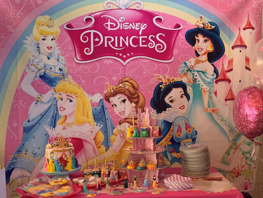 Pink and gold princess birthday party setup with custom cake, decorated cookies, and balloon arch.